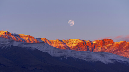 A mountain range ablaze with fiery hues as the sun sets the moon already beginning to appear above. . . - Powered by Adobe