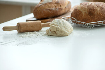 Dough and rolling pin ready to make bread is placed on the table