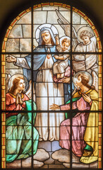 MILAN, ITALY - MARCH 6, 2024: The Madonna among the angels in the stained glass of the church Chiesa del Redentore by unknown artist (1933).