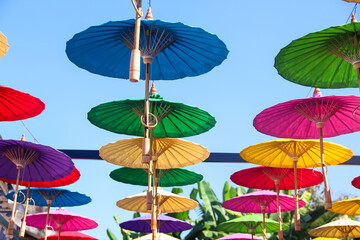 Fototapeta na wymiar Umbrella open with wood handle hanging on bright blue sky background