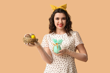Beautiful pin-up woman holding Easter eggs on color background