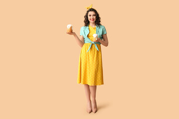 Happy pin-up woman holding Easter cakes on color background