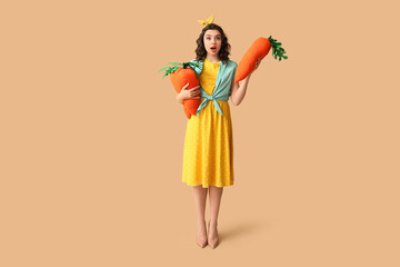 Emotional pin-up woman holding toy carrots on color background
