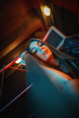 Beautiful futuristic girl posing in the neon lights. Cyberpunk concept.