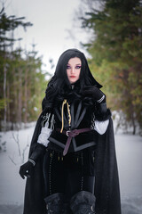 Beautiful young enchantress walking in the winter forest.