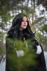 Beautiful young enchantress walking in the winter forest.