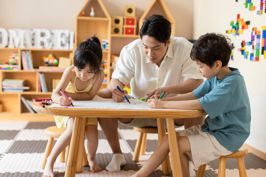 Little children painting in art class with teacher
