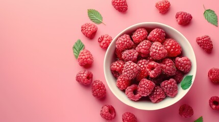 Ripe raspberries in a bowl on a pink background, juicy berries, vitamins.