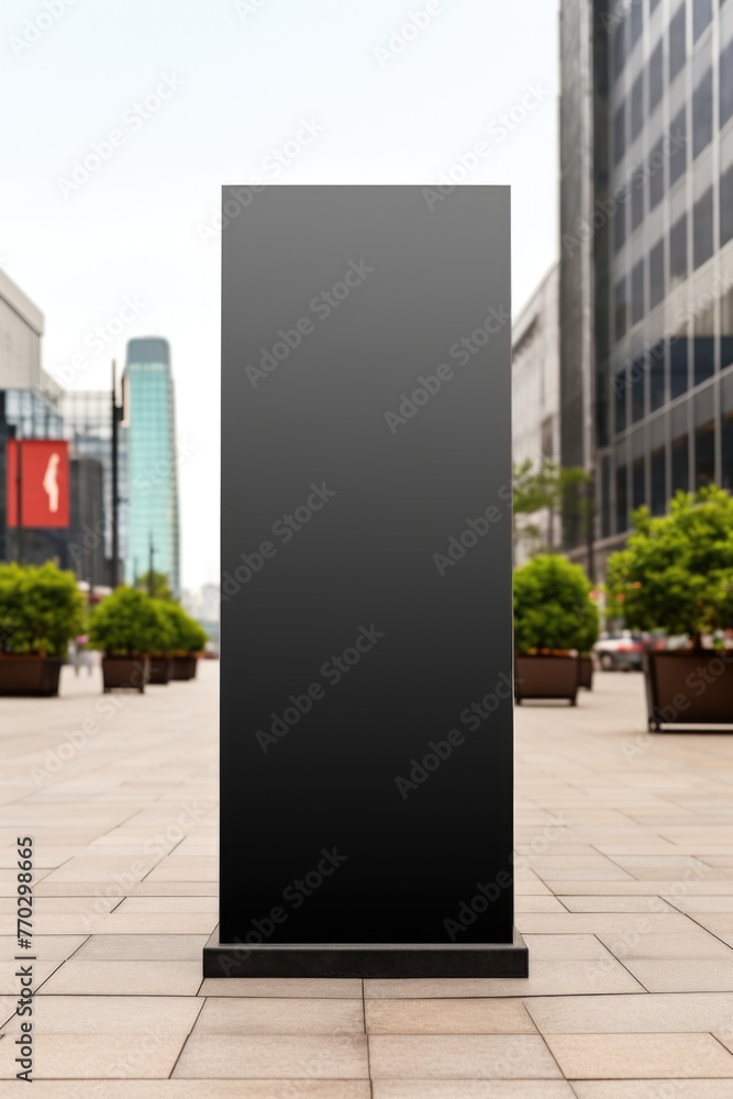 Poster a black sign is standing in front of a building. the sign is empty and has no writing on it. the sce