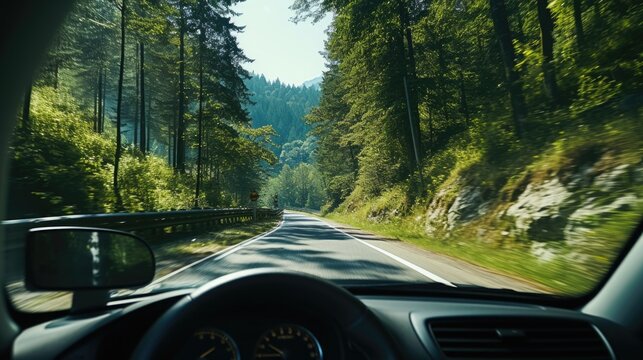 Fototapeta A car is driving down a road with trees in the background. The driver is looking out the window and enjoying the view