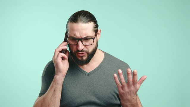 A close-up image showing a man with long hair and a beard appearing troubled and distressed as he engages in a heated phone conversation, his hand gesturing expressively. Camera 8K RAW. 