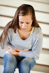 Stomach pain, stress and woman in a house with pms, gas or constipation, virus or gut health...