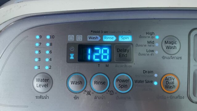 Phuket, Thailand - March 24, 2024 : Wash, rinse , spin button and time running down on working washing machine controller