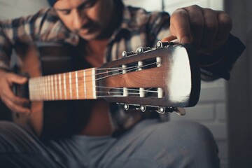 man practicing acoustic guitar
