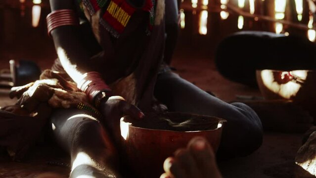A Hamer Tribe Woman and her cooking Bowls inside a Hut