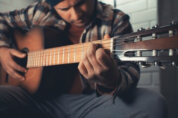 latin man practicing acoustic guitar