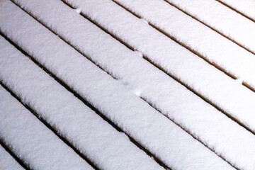 Full frame abstract texture background of fresh fallen white snow onto a wooden deck surface