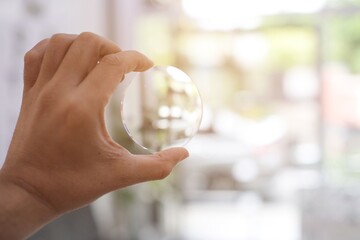 person holding a glasses lenses 