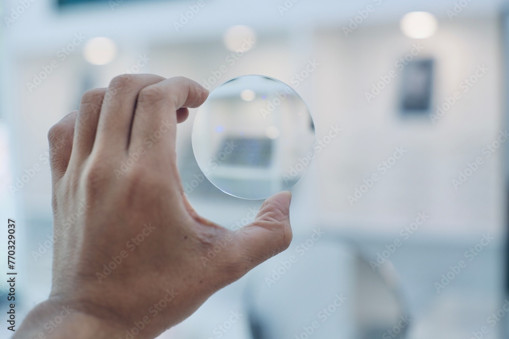 Wall mural hand holding glasses lenses