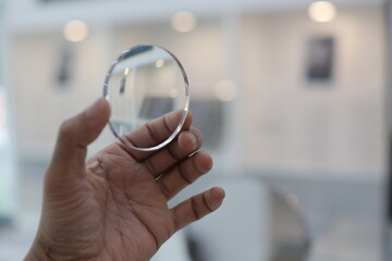 close up of a hand holding a glasses lense