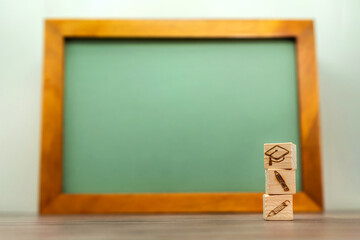 学生帽子と鉛筆を積み上げたブロックで学習をイメージした立てかけた黒板の背景