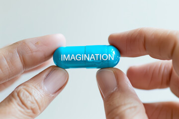 Fingers gently grasp a blue mini pill adorned with the word "IMAGINATION" highlighting the power of creative thinking.