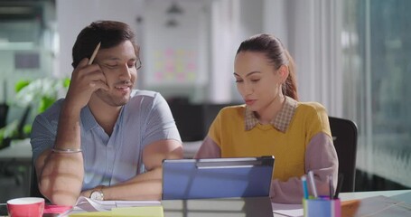 Asian Indian Hindu happy young adult girl boy staff team sitting chair do talk use tablet gen z female male pair man lady intern friends hold pen share project plan ideas help in new work job office	 - Powered by Adobe