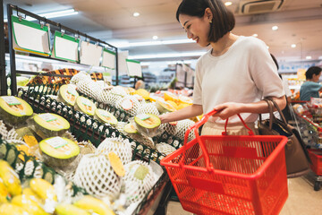 Asian woman consumer choosing organic vegetable product  at supermarket store - obrazy, fototapety, plakaty