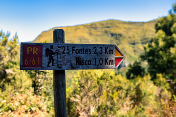 This photo depicts wooden signs in Madeira, indicating directions to. These markings point to the...