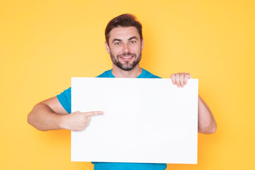 Information concept. Man with blank placard. Demonstrating copy space for your text or design. Man showing empty advertisement board on studio background. Blank placard, signboard for ad.