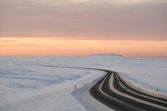 Road in wintertime under sundown sky