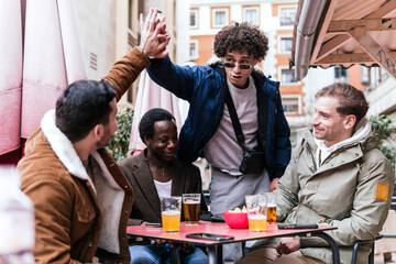 four multi ethnic friends drinking beers and talking