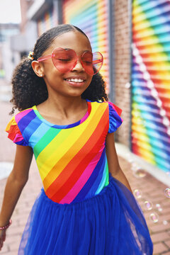 Young Girl smiling with bubbles in front of a mural in Washington, DC