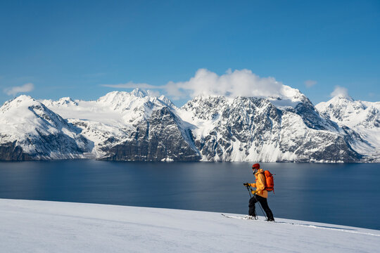 Man splitboarding on snow covered land by sea during vacation