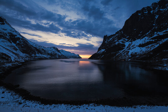 Scenic View Of Sea Amidst Mountains Against Sky At Sunset