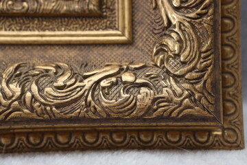 the corner of the frame for the picture is made of an antique baguette of golden color
