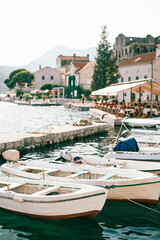 Fototapeta na wymiar White wooden fishing boats are moored at the pier. Perast, Montenegro