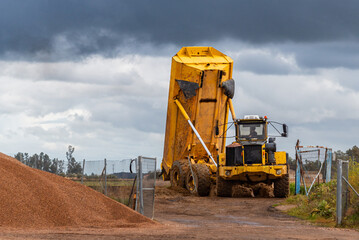Haul truck unloading soil in a quarry, specific truck for closed areas.