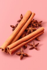 Cinnamon and anise on a pink background.