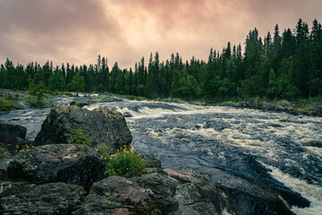 Twilight Above the Rapids Amidst Boulders in Dalarna, Sweden. On a summer evening, rushing water...