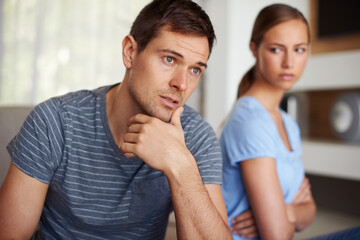 Couple, disappointed and fight in home on sofa with stress or angry and sad with marriage issues. Relationship, confrontation and argument in living room on couch with conflict and emotional