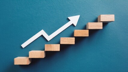 A minimalist design of wooden blocks stacked to form a step staircase, with a white arrow pointing upwards on a blue background. Symbolizes the continuous striving for achievement and progress.