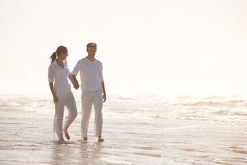 Couple, ocean and holding hands on beach, travel and commitment with trust and bonding with walking outdoor. Love, care and support in relationship, honeymoon or anniversary with peace in nature