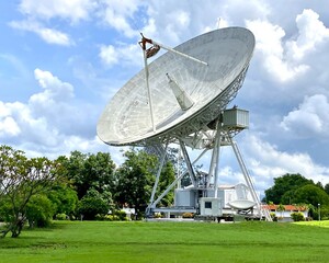 Large satellite dish and station with cloudy sky for telecommunications and broadcasting in Thailand - obrazy, fototapety, plakaty