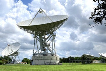 Group of large satellite dishes with cloudy sky for telecommunications and broadcasting in Thailand - obrazy, fototapety, plakaty