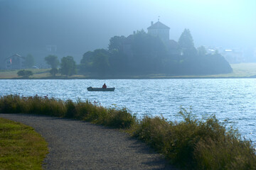 Fishing boat on the lake. Relaxing on the water in the fog. Swiss, Lake Silvaplana.