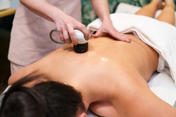 Shockwave therapy for muscular health by a skilled health professional on a patient's back