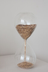hourglass with gold in white studio