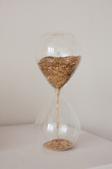 hourglass with gold in white studio
