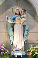Closeup of Statue of Our lady virgin Mary with Child Jesus located in front of the catholic church with natural background, Thailand. selective focus.